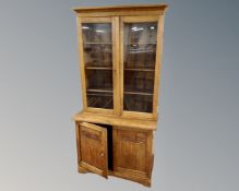 A Scandinavian oak double door glazed bookcase fitted with cupboards below.