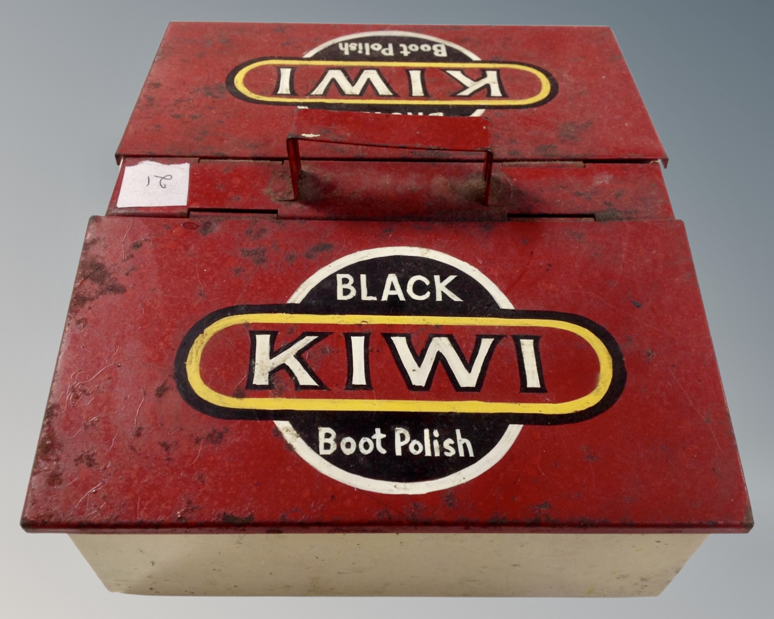 A painted metal boot polish box.