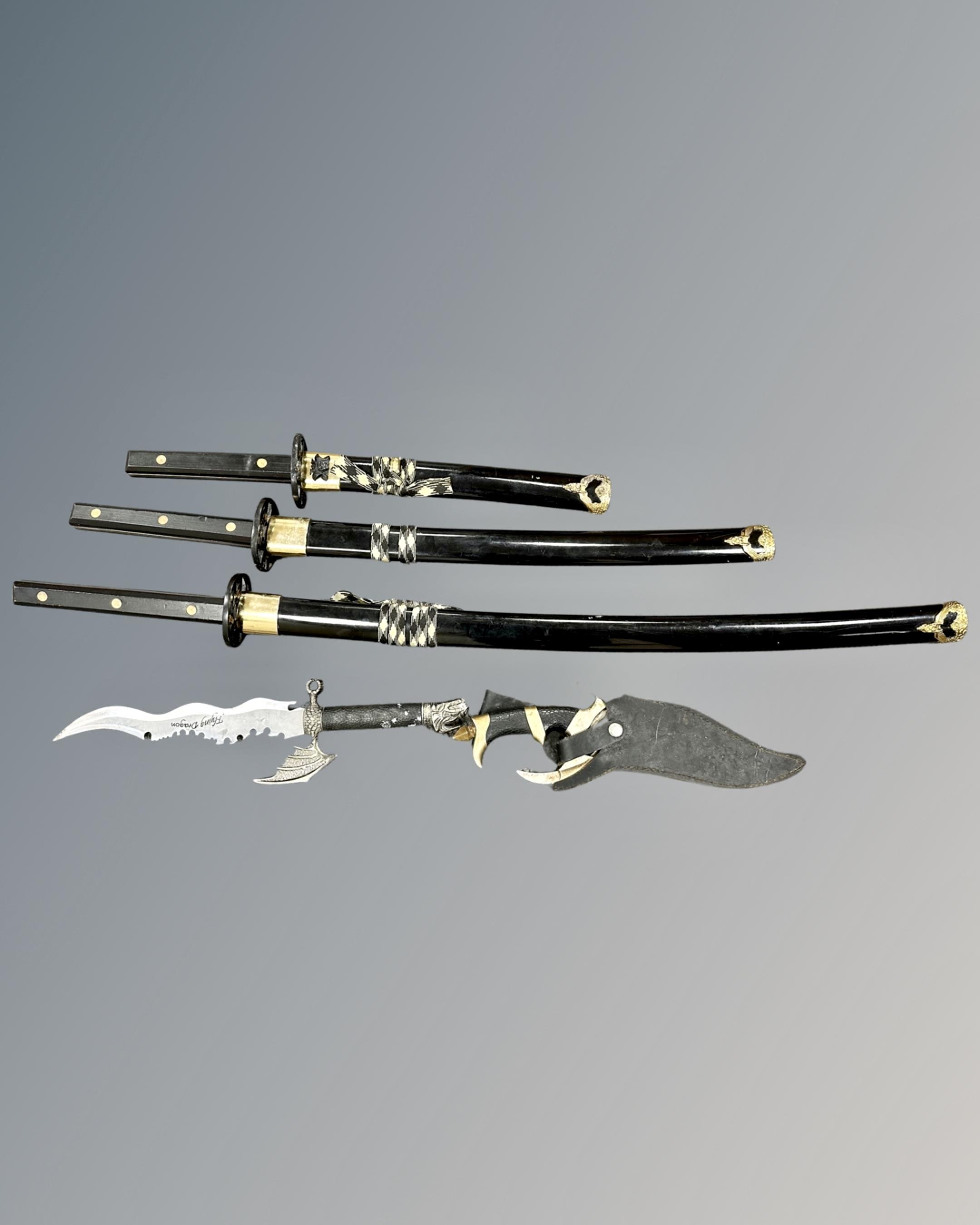 A set of three graduated Japanese style katanas together with two further fantasy knives,