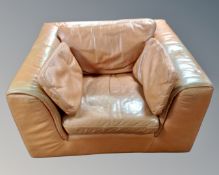 A 1970's low armchair, upholstered in tan leather.