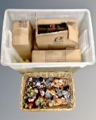 A box containing a quantity of cake decorations and a further wicker basket containing toys.