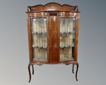 A 19th century inlaid mahogany shaped front double door display cabinet with leaded glass doors