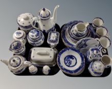 Two trays containing a quantity of Ringtons blue and white willow pattern tea and dinner china.