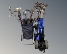 A golf bag and shopping trolley containing a large quantity of assorted golf clubs, walking sticks,