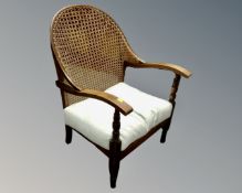 A 20th century beech framed bergere backed low armchair.