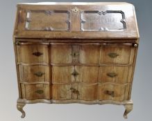 A 19th century oak serpentine fronted bureau secretaire fitted with three drawers below.