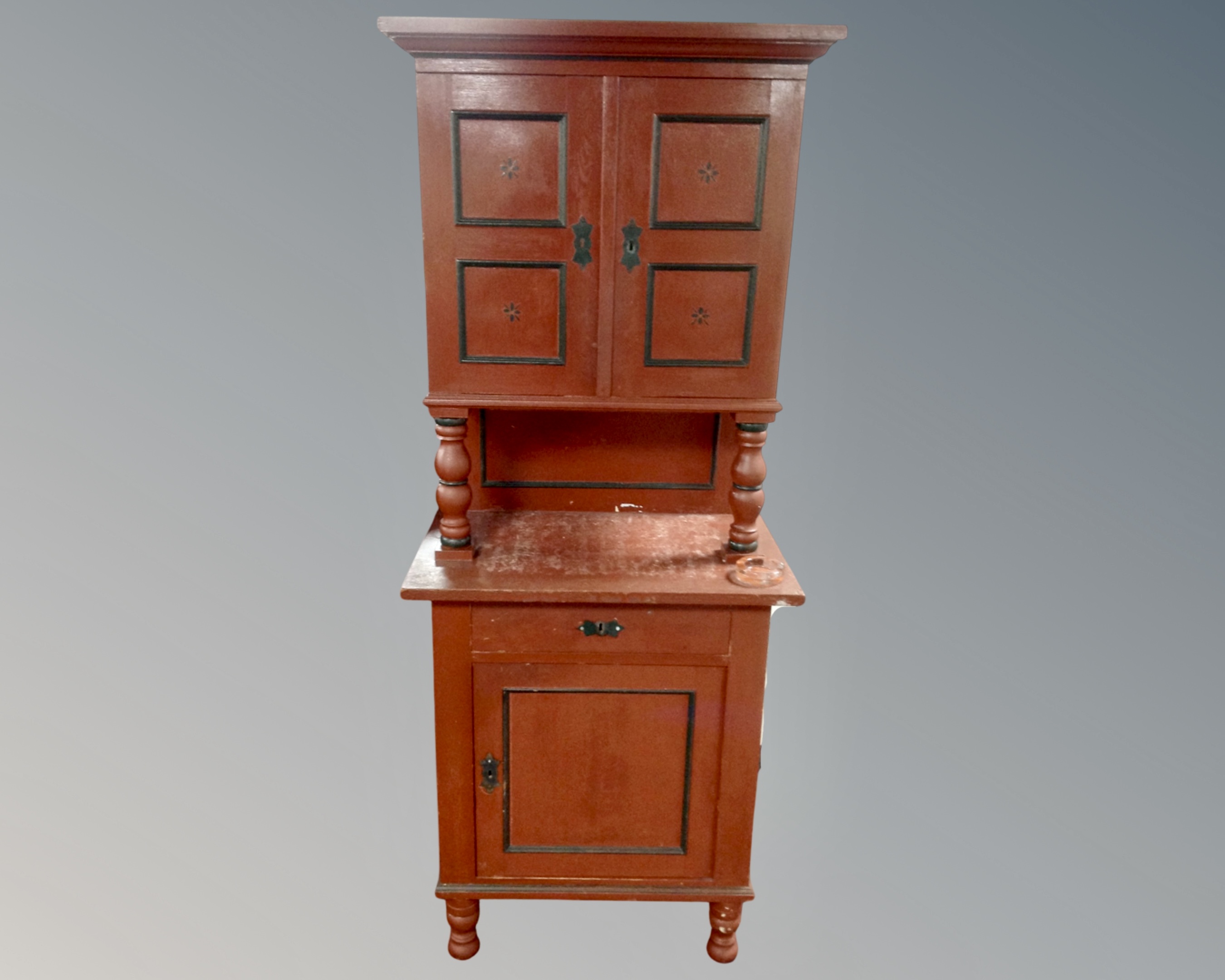 A painted continental pine cupboard on raised legs fitted with a drawer and double door cupboard