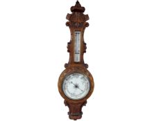 An Edwardian carved oak aneroid barometer.