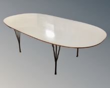 A contemporary oval boardroom table on hairpin metal legs.