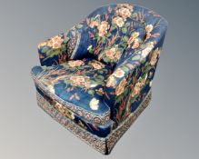 A 1980s lowback armchair upholstered in floral fabric.