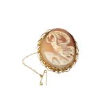 An ornate gold cameo brooch with gold safety chain