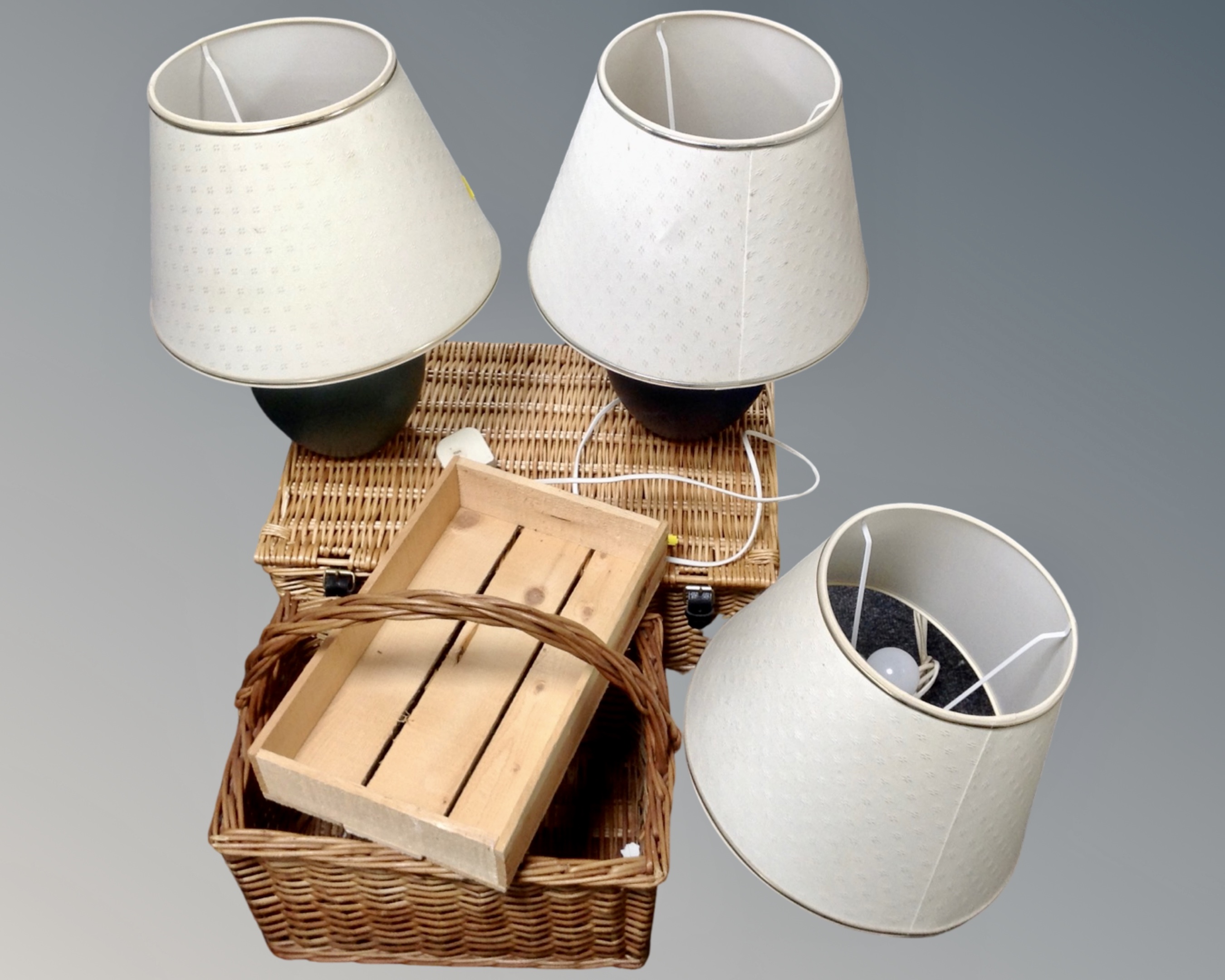 A wicker hamper, a wicker wine basket, a pine trough and three contemporary table lamps.