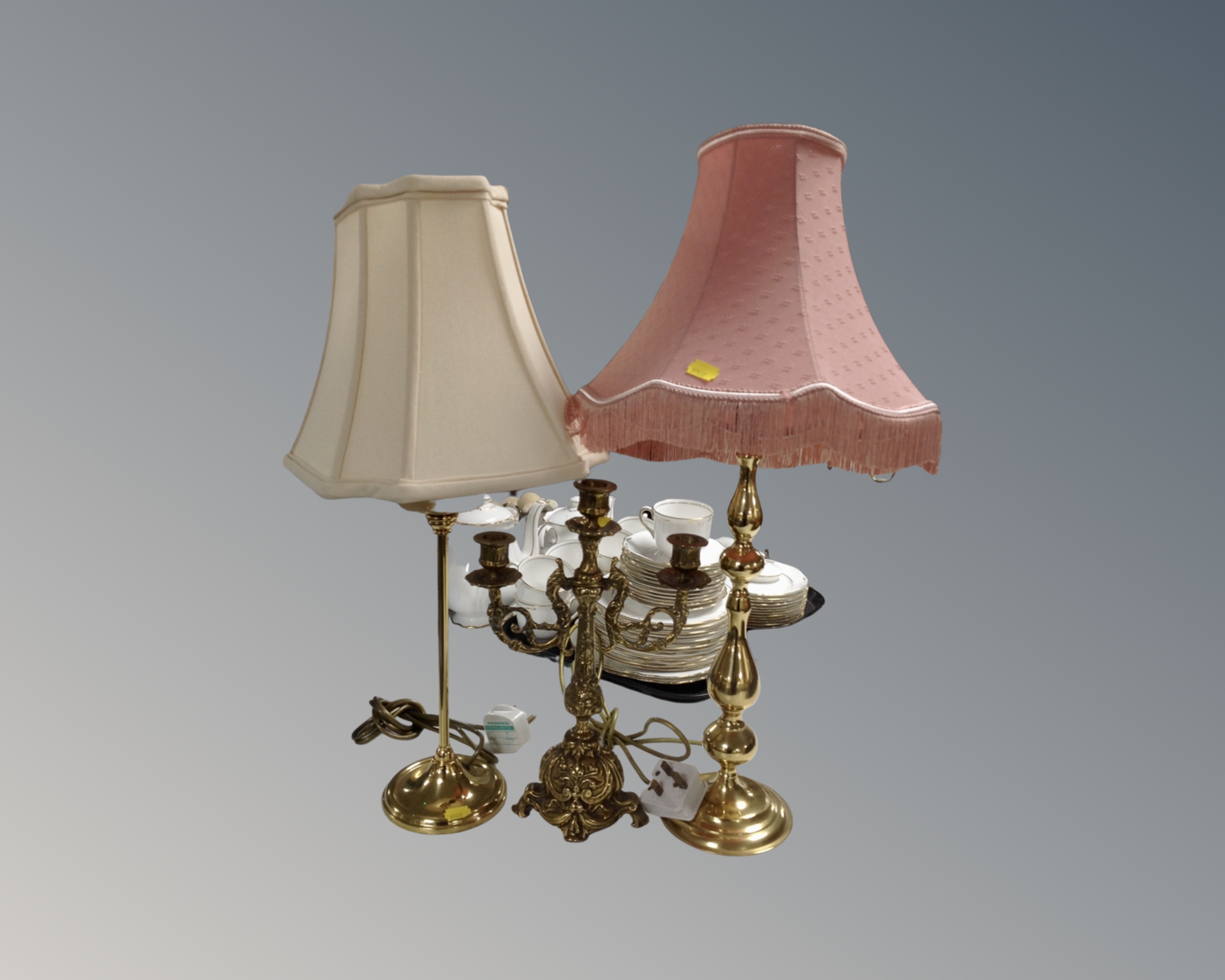 A gilt metal three way table candelabrum together with two brass table lamps, with shades.