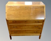 A mid-20th century secretaire bureau on raised legs fitted with four drawers beneath.