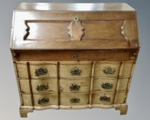 A 19th century oak serpentine fronted secretaire bureau fitted with four drawers beneath.