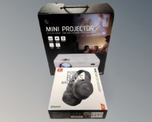 A Goodmans mini projector together with a set of JBL Pure Bass wireless headphones,