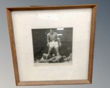 A black and white print of Muhammad Ali, in frame and mount.