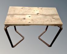 A rustic pine topped occasional table on copper pipe legs.