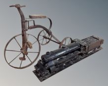 A miniature penny farthing together with a wooden folk art model of a train.