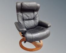 A Scandinavian Fjords swivel relaxer armchair with headrest, upholstered in black leather.