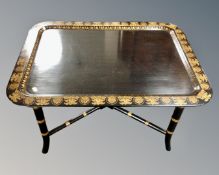 A Regency style black and gilt tray table.