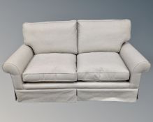 A two seater bed settee upholstered in a beige fabric.