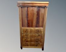 A 19th century Biedermeier double door cabinet fitted with four drawers beneath and pillar column