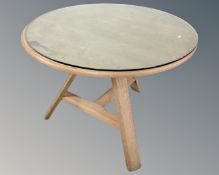 A contemporary circular Arts and Crafts style dining table with a plate glass top.
