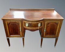 A 19th century inlaid mahogany bow fronted double door sideboard on raised legs fitted with a