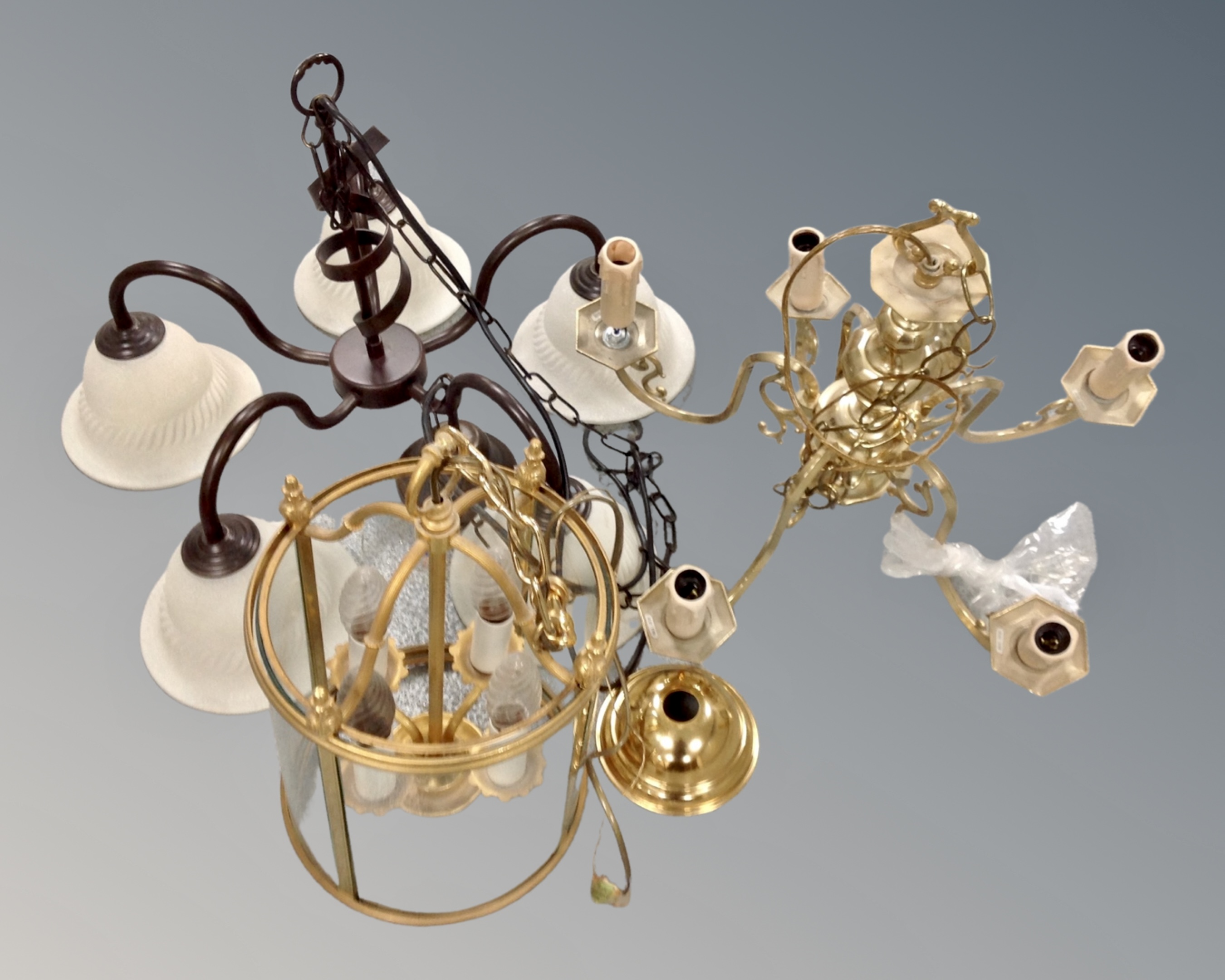 A contemporary metal five-way light fitting with shades together with a further brass five-way