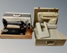 A vintage Singer hand sewing machine in case together with a Singer electric sewing machine in case.