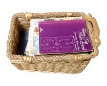 A wicker basket containing sheet music and music books.