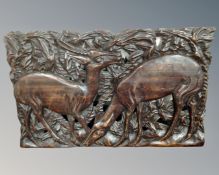 A carved African hardwood frieze depicting antelopes
