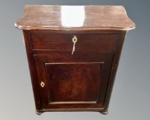 An antique serpentine fronted cupboard fitted with a drawer above.