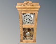 An early 20th century oak wall clock with silvered dial.