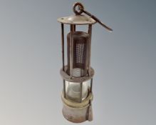 A 19th century miner's Davy lamp with exposed gauze centre enclosed in five bars,