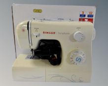 A Singer Symphonie electric sewing machine with original box.
