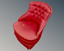 A 20th century button back bedroom chair upholstered in a red fabric.