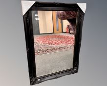 A contemporary black framed mirror, 66cm by 90cm.