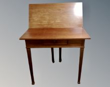A mahogany turnover top tea table on reeded legs fitted with a drawer.