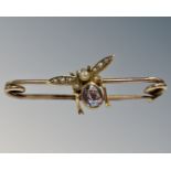 An antique yellow gold bar brooch mounted with seed pearl and amethyst winged insect, 2.5g gross.