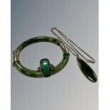 A moss green jade bangle mounted in white metal, internal diameter 60 mm,