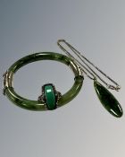 A moss green jade bangle mounted in white metal, internal diameter 60 mm,