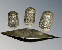 Three silver thimbles and a silver spool.