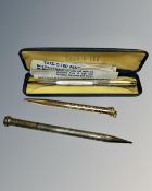 A sterling silver pencil together with two further gold plated examples.