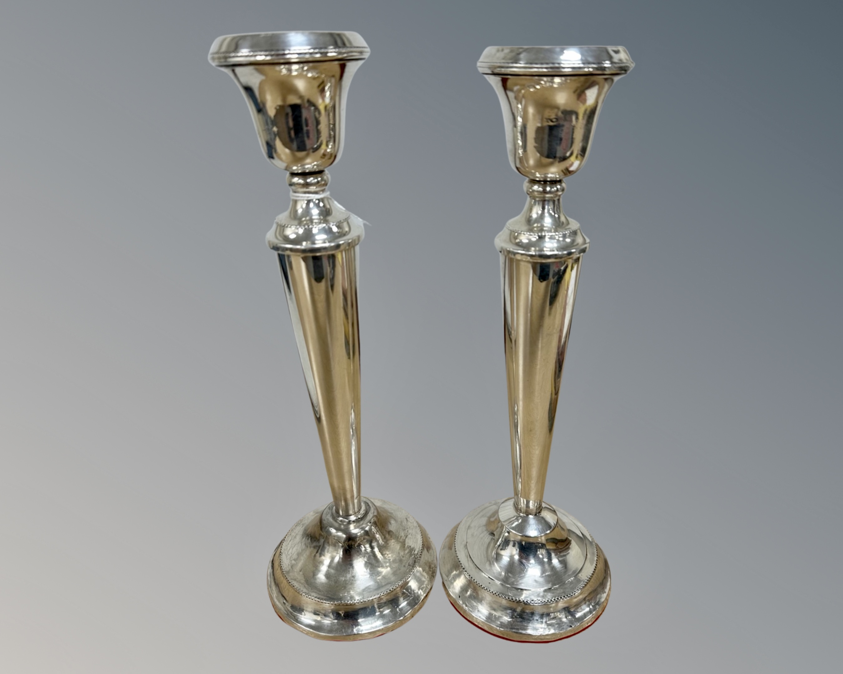 A pair of loaded silver candlesticks, marks rubbed, height 29.5cm.