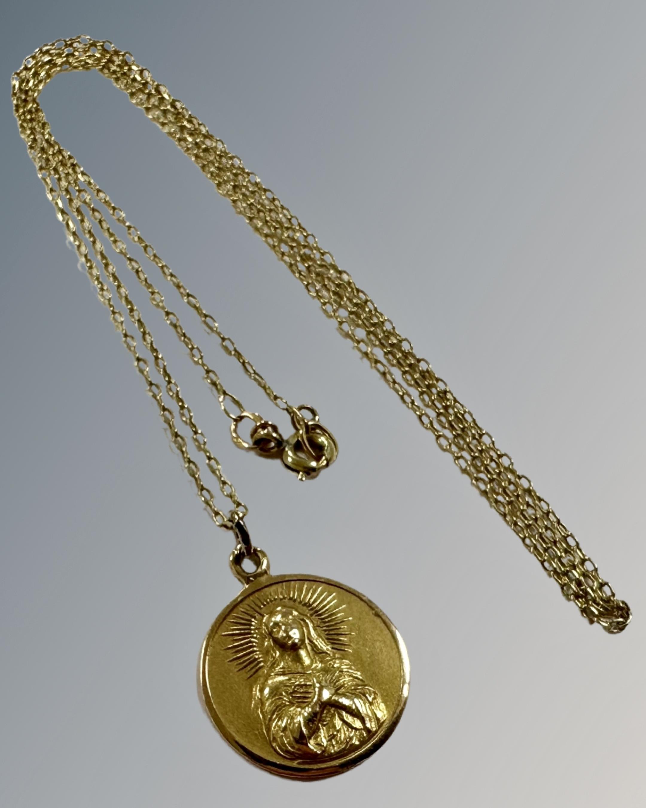 A yellow gold fine necklace with religious pendant, 5g.