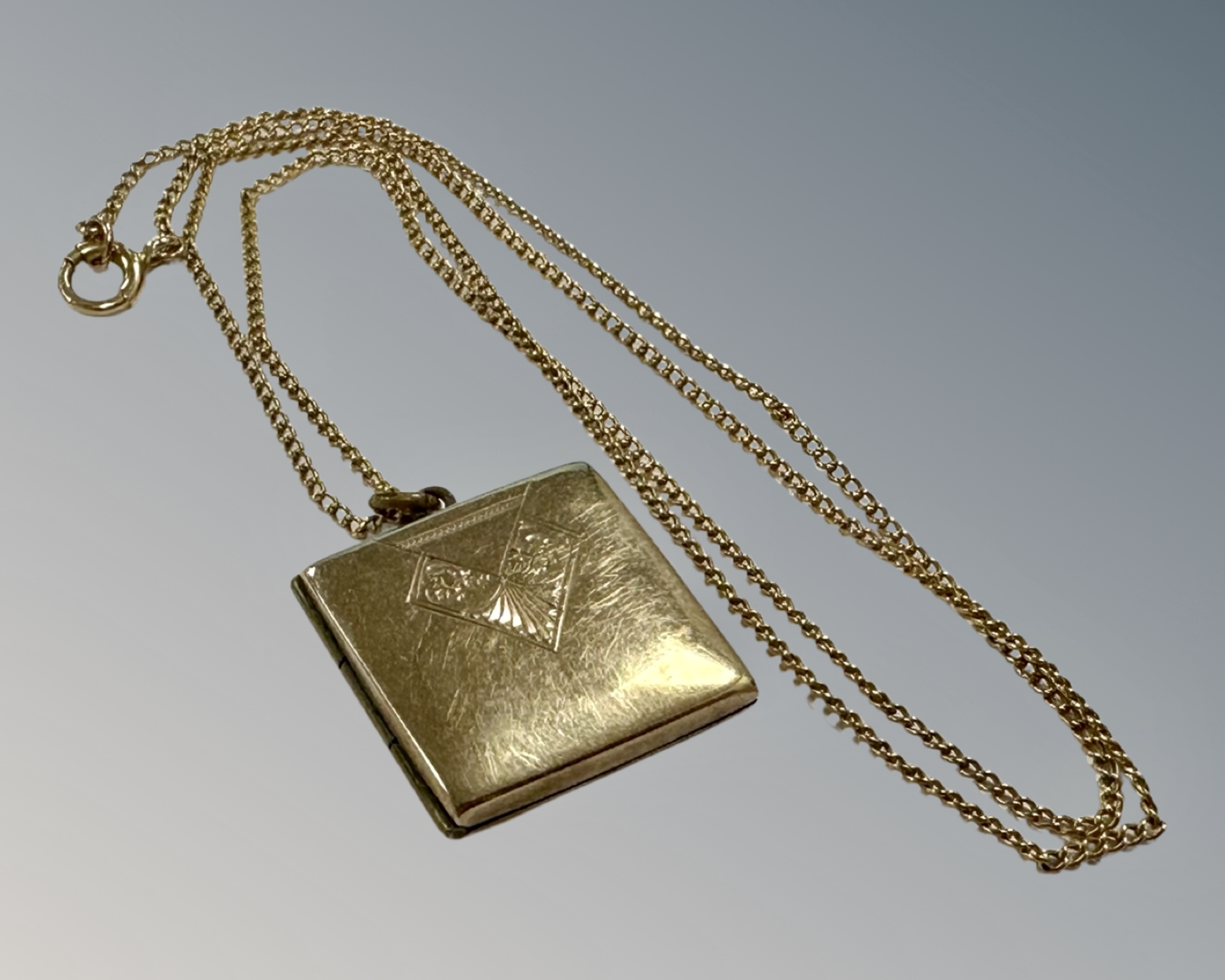 A 9ct yellow gold chain with rolled gold square locket