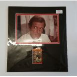 CINEMA, James Bond, signed trade card by Roger Moore, overmounted beneath colour photo showing him