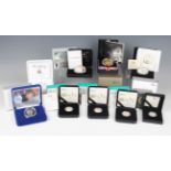 A collection of Elizabeth II Mint commemorative coins, including a gold plated silver proof five